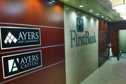 Magnesium plaques with silver letters installed on wood wall at First Bank