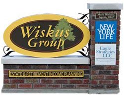 Freestanding Wiskus Group storefront sign mounted on brick base