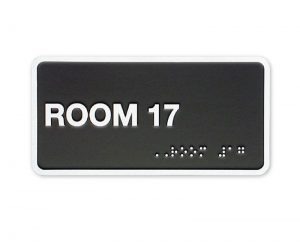 Black ADA sign for room with Braille