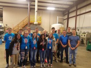 New Horizons students pose with PEC owners inside workshop