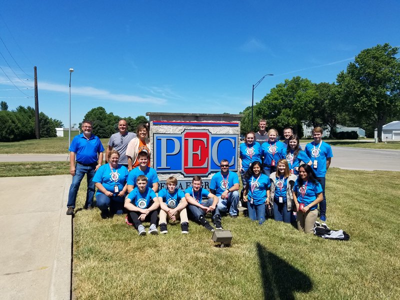 Business Horizons students pose with PEC owners in front of PEC sign