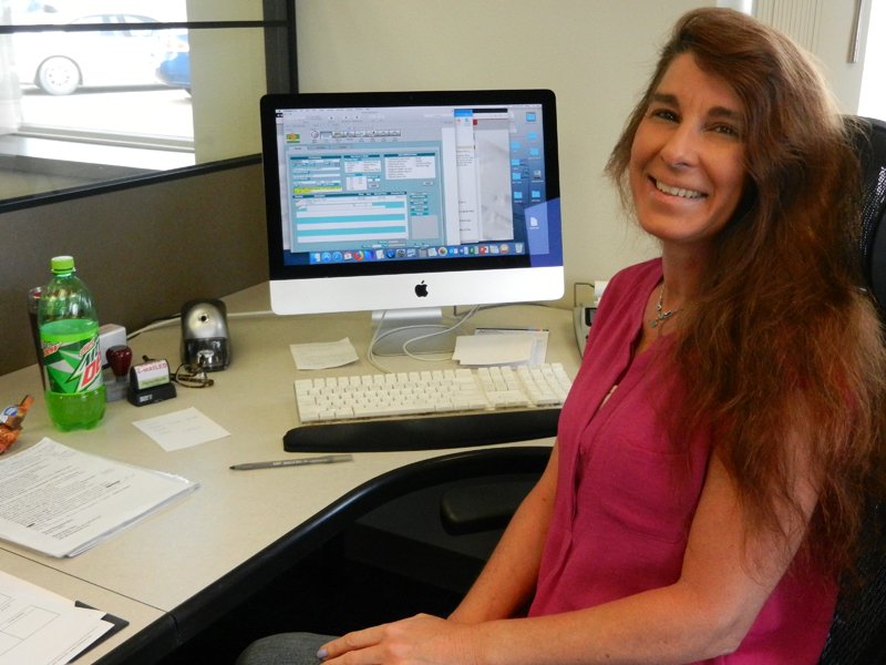 Kelly Walters seated at her desk in front of her computer