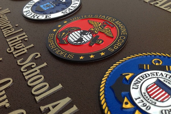 Closeup of color-filled U.S. military seals on magnesium plaque