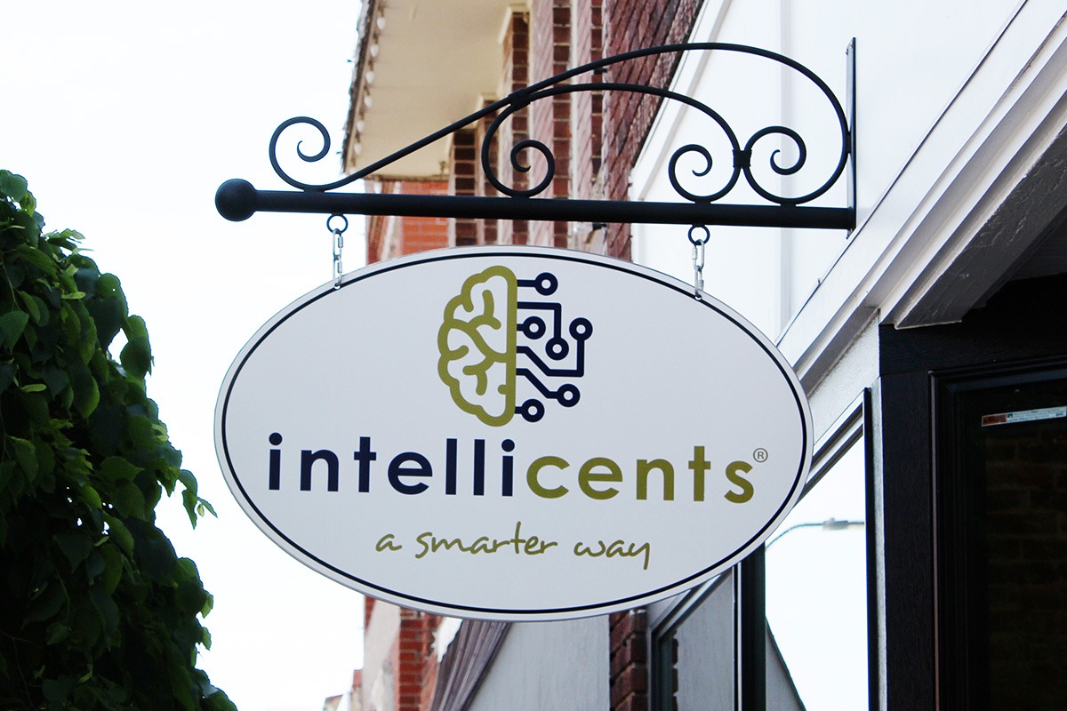 Wall-mounted hanging Intellicents storefront sign with brain logo