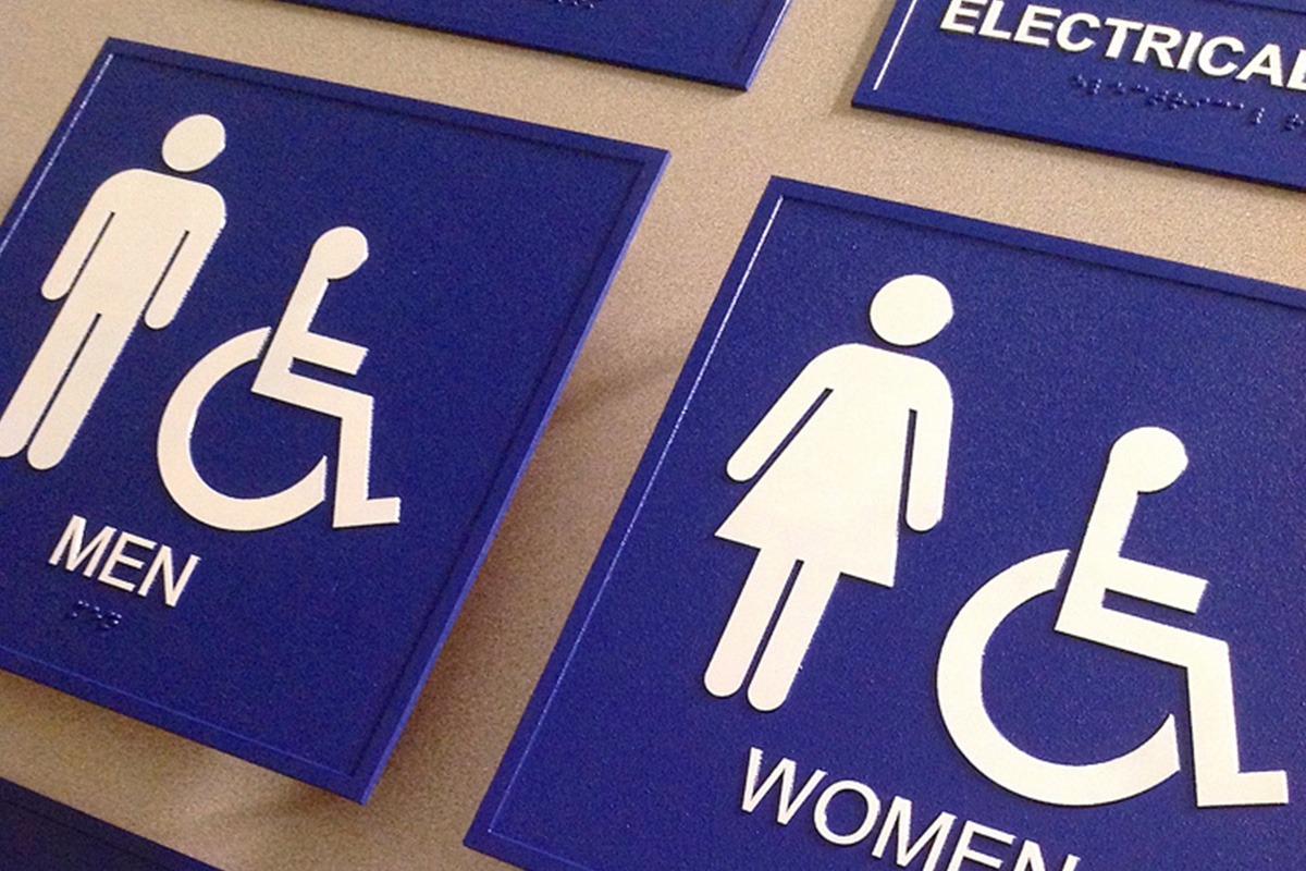 Blue and white bathroom signage with braille
