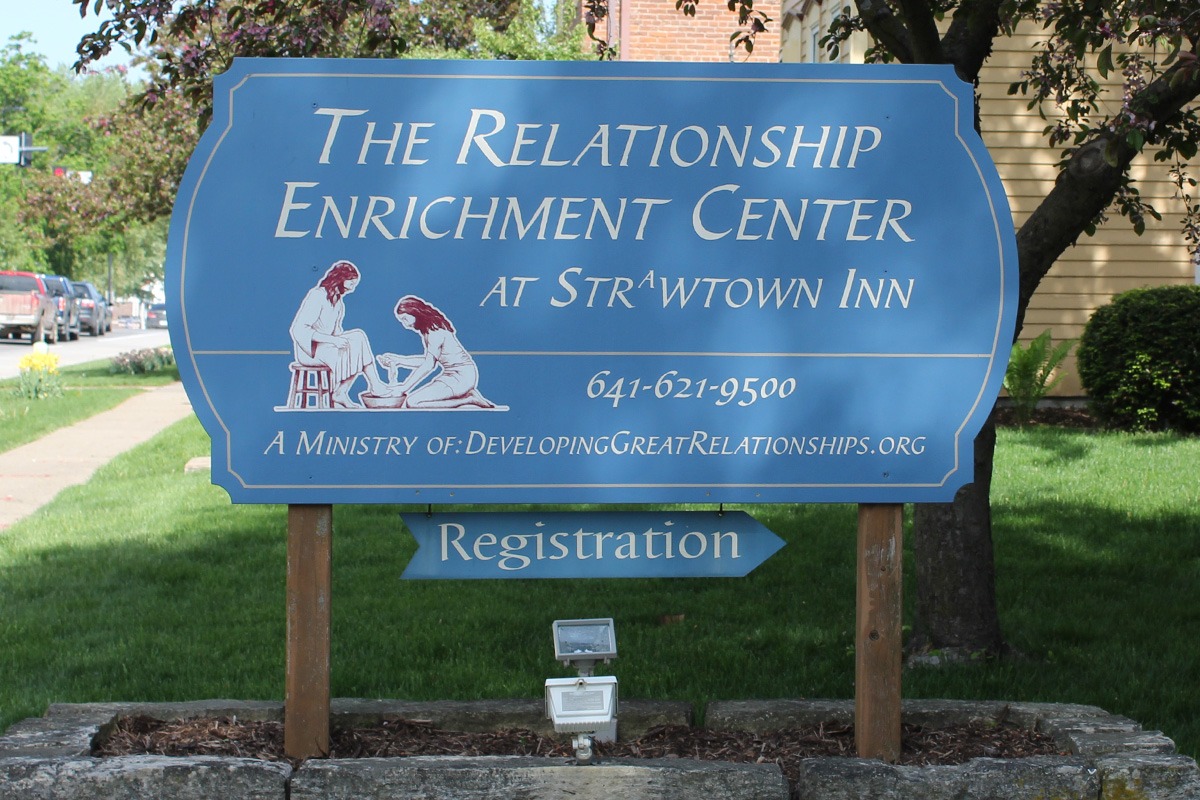 Blue post-and-panel sign with Biblical scene for The Relationship Enrichment Center