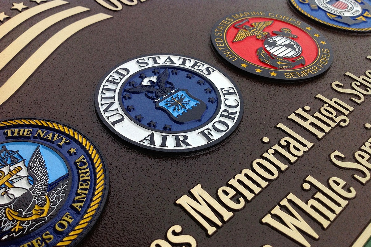 Closeup of magnesium plaque featuring color-filled U.S. military seals