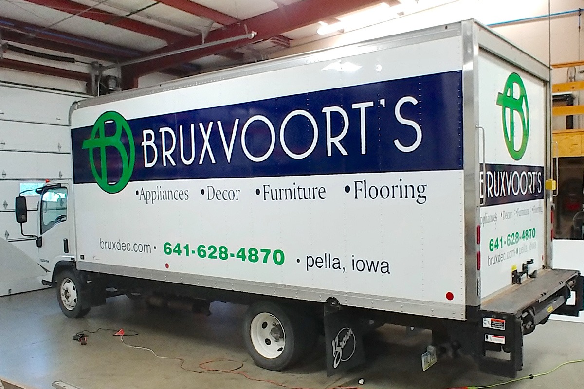 Green, blue, and white vehicle wrap on Bruxvoort's box truck