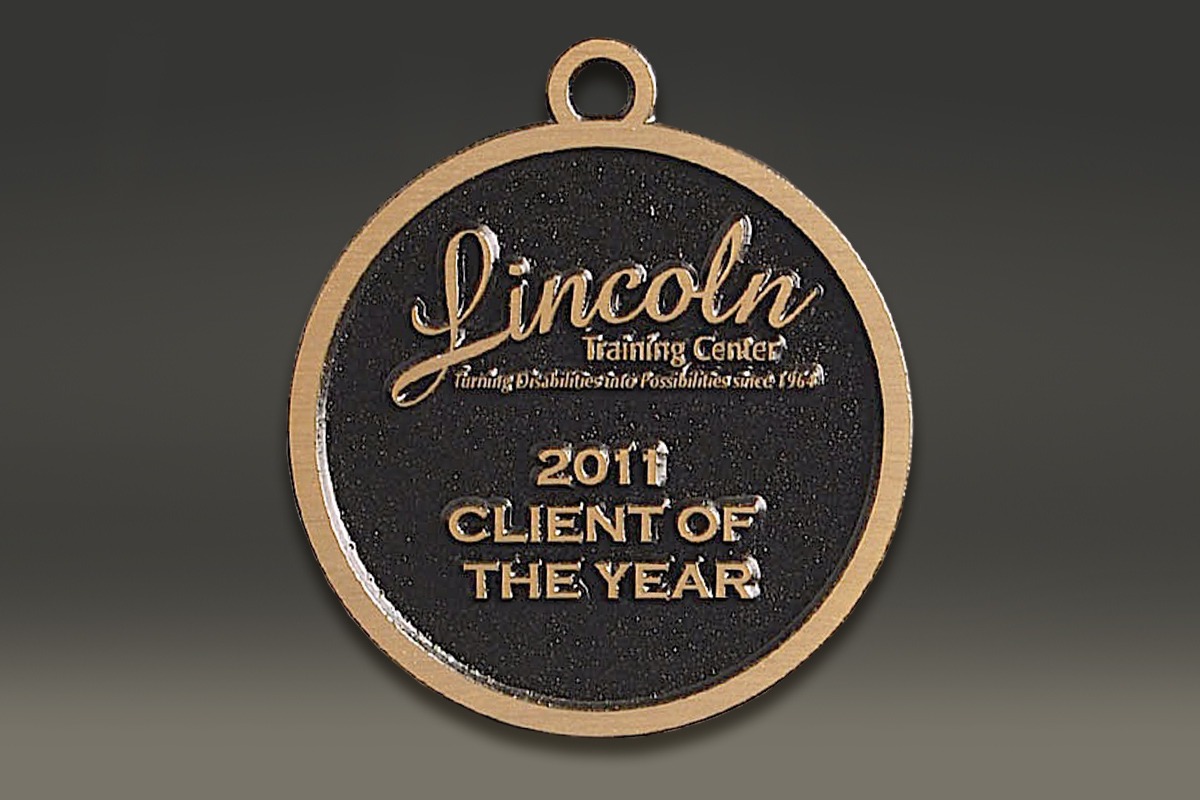 Black and gold Lincoln Training Center zinc medallion