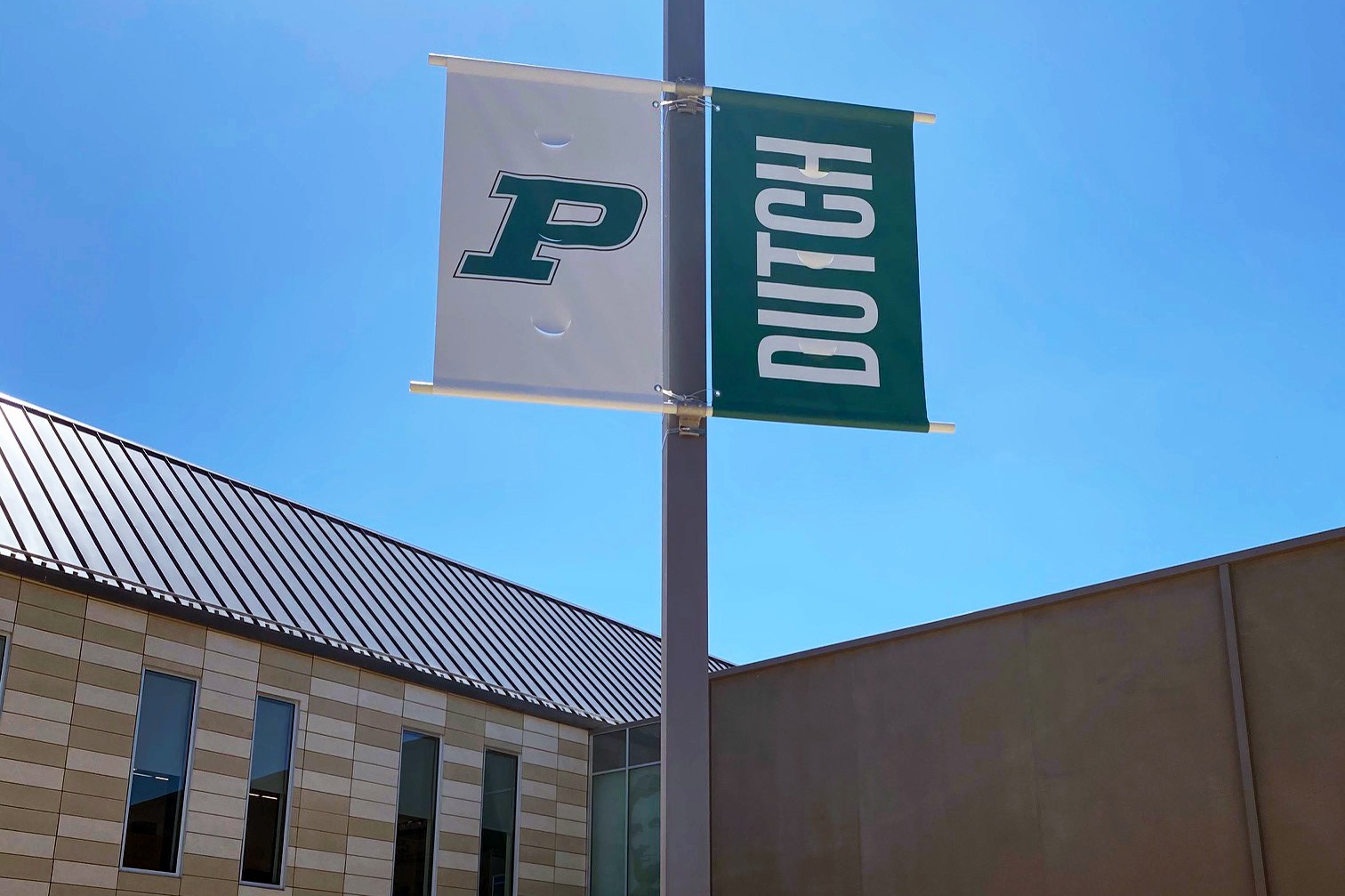 Two Pella Dutch banners on lampposts in school parking lot