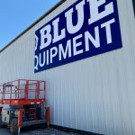 Closeup of Blue Equipment sign being installed